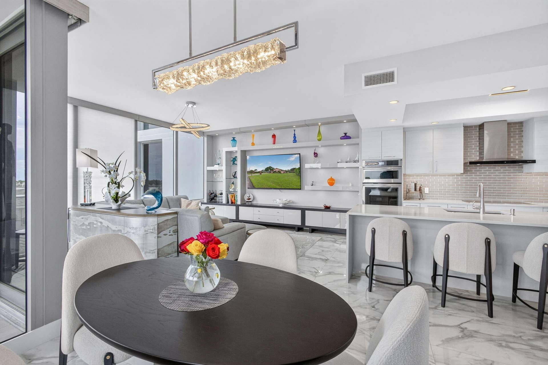 1 Water Club Way, #503, North Palm Beach, FL 33408 Modern kitchen featuring integrated appliances, light-toned cabinetry, and a textured tile backsplash