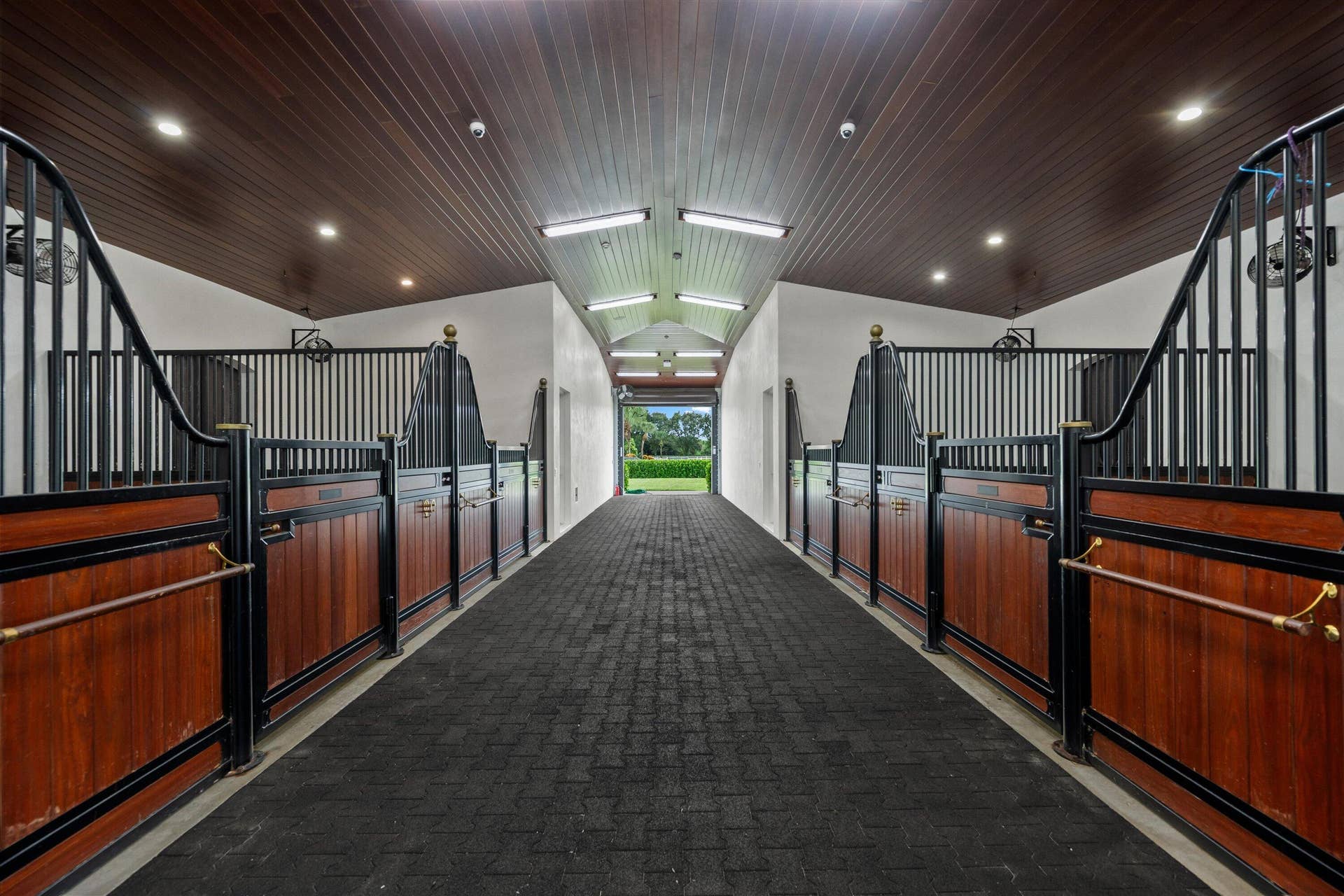 843 STALLION Drive, Loxahatchee, FL 33470 Stall barn featuring wood-paneled walls, black metal accents, a wood plank ceiling, recessed lighting, and a textured paver walkway