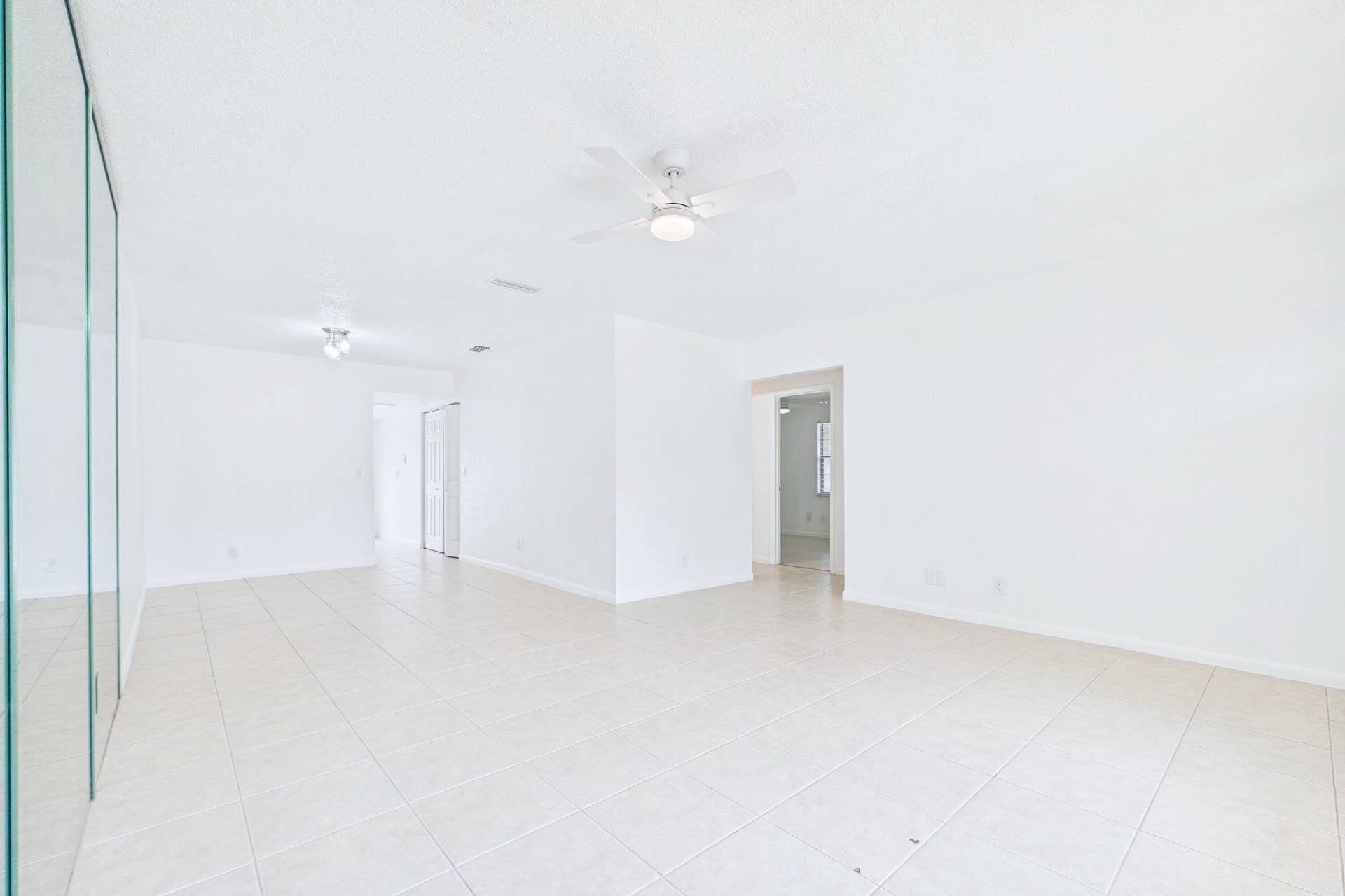 Expansive room featuring tile flooring, and a ceiling fan