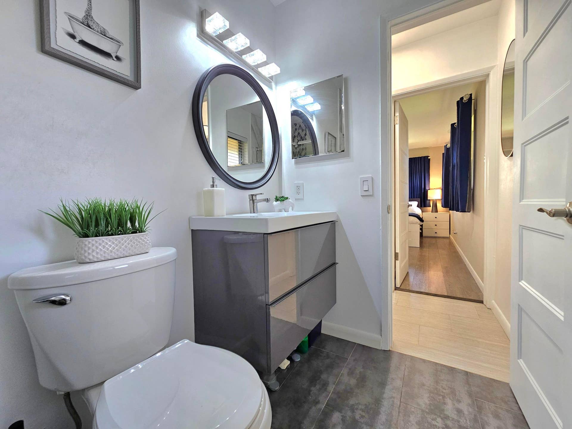 ANOTHER VIEW OF THE BATHROOM WITH SLEEK VANITY AND PLENTY STORAGE ROOM