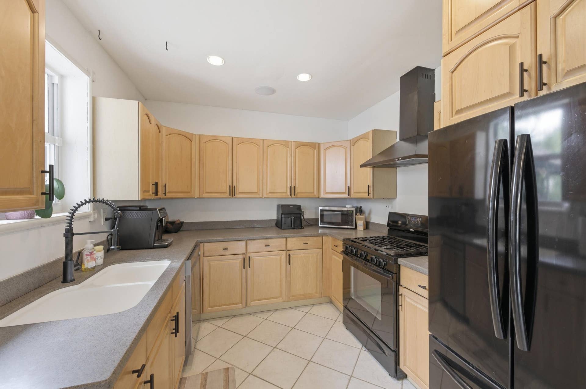 1421 SW 20 Street, Fort Lauderdale, FL 33315 Kitchen featuring light wood cabinetry, recessed lighting, double basin sink with a gooseneck faucet, black appliances, and tile flooring