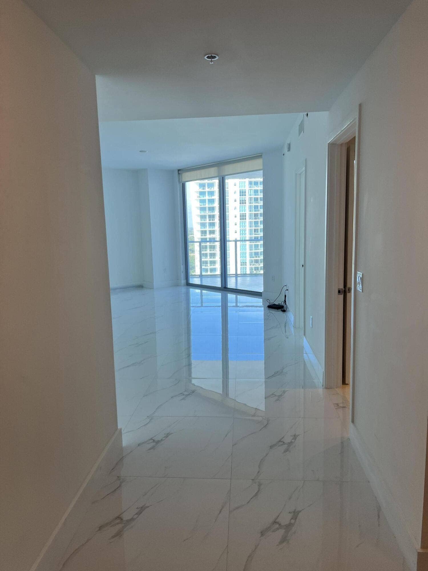 17111 BISCAYNE Boulevard, #1903, North Miami Beach, FL 33160 Polished tile flooring, recessed ceiling lighting, floor-to-ceiling windows, and a balcony