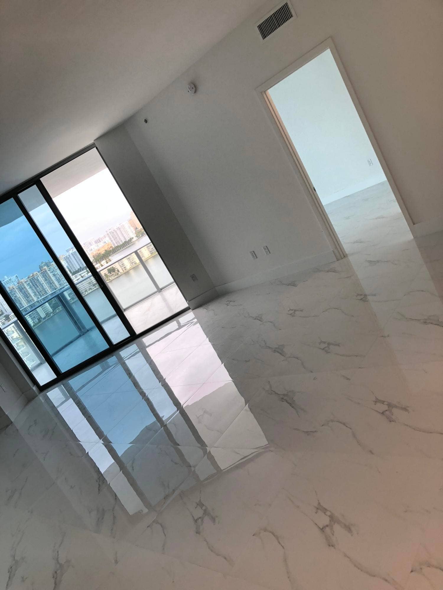 17111 BISCAYNE Boulevard, #1903, North Miami Beach, FL 33160 Glossy tile flooring, expansive windows, recessed lighting, and a neutral color palette