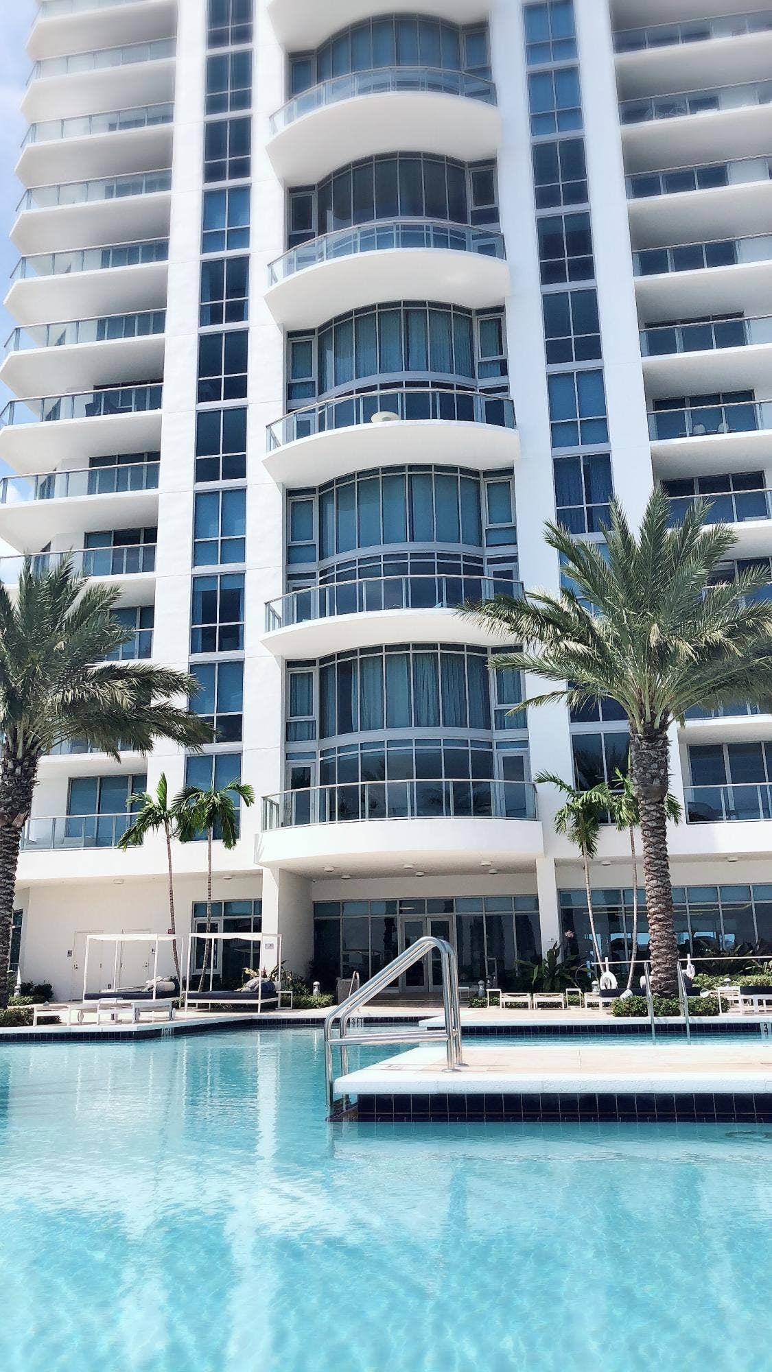 17111 BISCAYNE Boulevard, #1903, North Miami Beach, FL 33160 Contemporary high-rise building with multiple curved balconies, floor-to-ceiling windows, and an expansive outdoor pool area