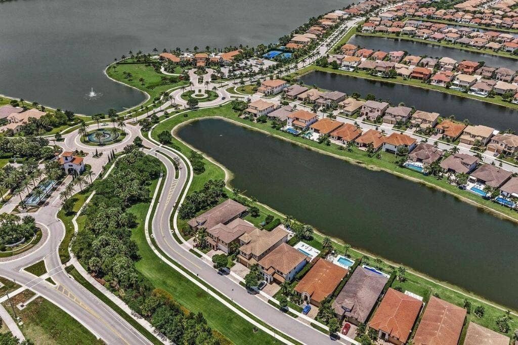 12143 S Baypoint Circle, Parkland, FL 33076 Aerial perspective of a planned residential community featuring numerous waterfront properties, multiple large water bodies, and extensive green spaces