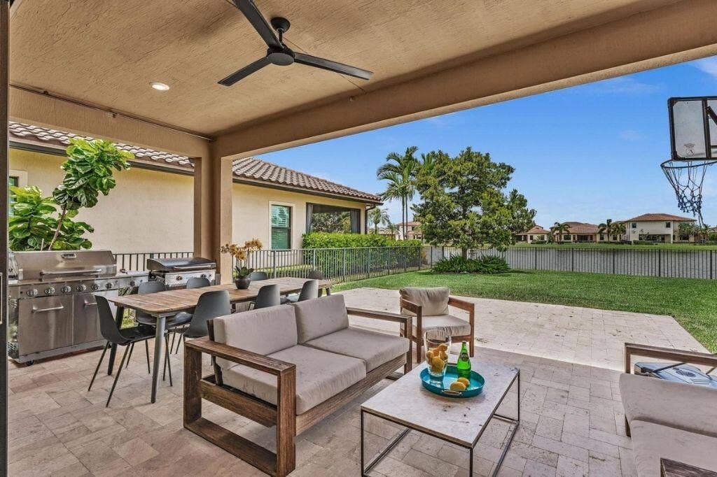 12143 S Baypoint Circle, Parkland, FL 33076 Expansive covered patio featuring a paver flooring, outdoor ceiling fan, and built-in grill station