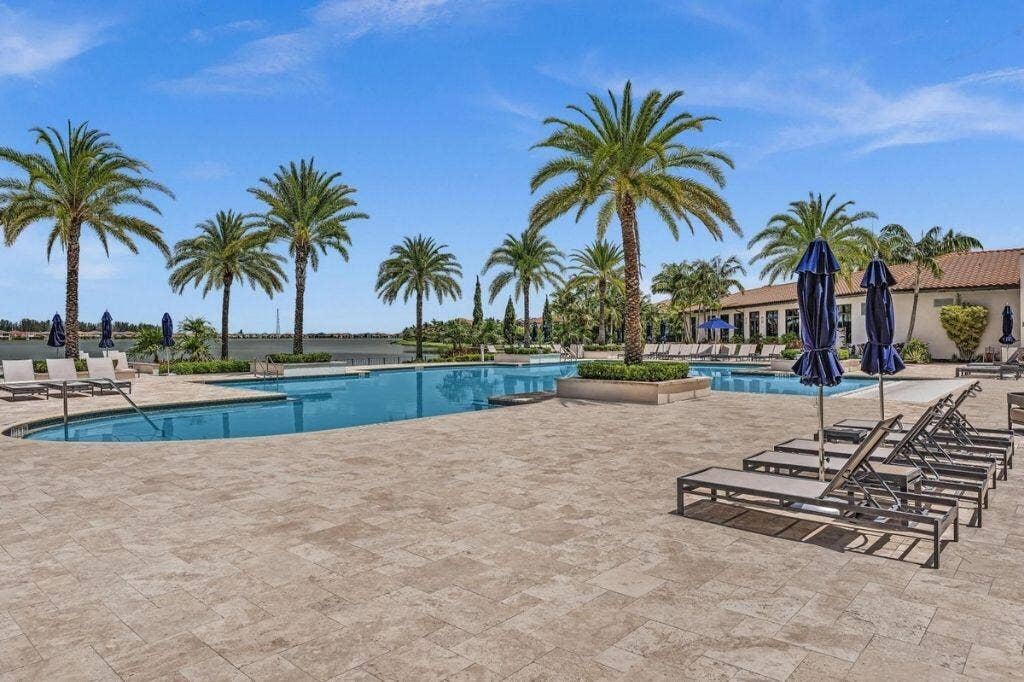 12143 S Baypoint Circle, Parkland, FL 33076 Outdoor swimming pool with integrated spa and spacious surrounding patio