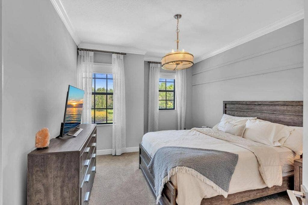 12143 S Baypoint Circle, Parkland, FL 33076 Light gray walls with crown molding, two windows with gridded panes, and a decorative ceiling light fixture