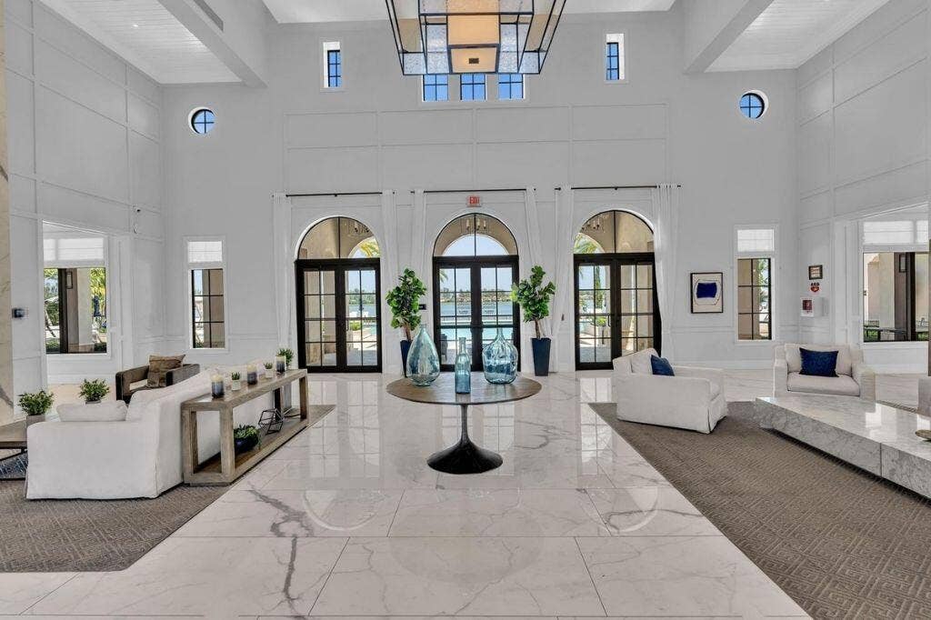 12143 S Baypoint Circle, Parkland, FL 33076 Grand foyer featuring a high ceiling, polished marble-finish flooring, arched glass-paned doors, and transom windows