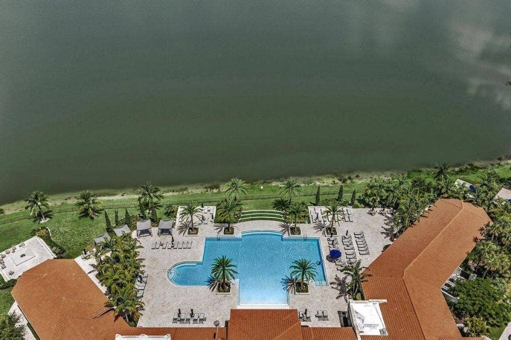 12143 S Baypoint Circle, Parkland, FL 33076 Resort-style pool area featuring a large swimming pool, expansive paved patio, and multiple lounge seating areas