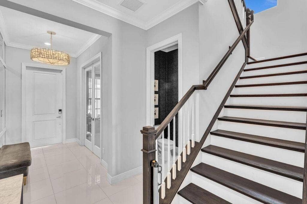 12143 S Baypoint Circle, Parkland, FL 33076 Grand staircase featuring dark wood treads and handrails with white risers and balusters
