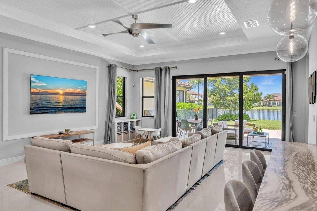 12143 S Baypoint Circle, Parkland, FL 33076 Spacious living area featuring large sliding glass doors opening to the patio and waterfront