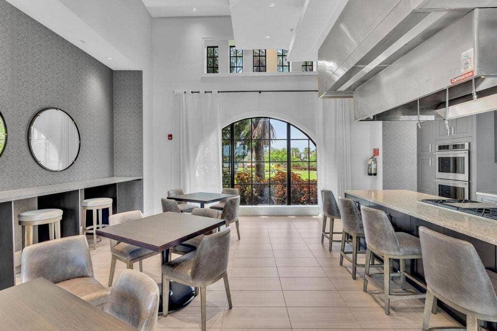 12143 S Baypoint Circle, Parkland, FL 33076 Spacious common area featuring a professional-grade kitchen, an oversized island with bar seating, and a large arched window