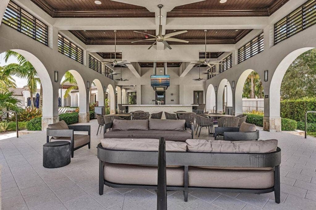 12143 S Baypoint Circle, Parkland, FL 33076 Open-air covered patio area featuring a high vaulted wood-finish ceiling, multiple ceiling fans, and arched doorways