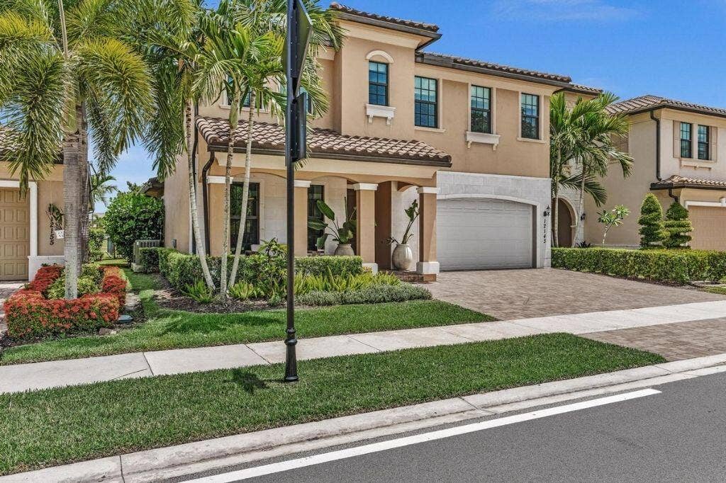 12143 S Baypoint Circle, Parkland, FL 33076 Two-story residence featuring a stucco exterior, barrel tile roof, and a paver driveway