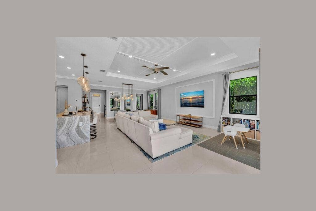 12143 S Baypoint Circle, Parkland, FL 33076 Spacious open-concept living area featuring a tray ceiling with recessed lighting and a ceiling fan