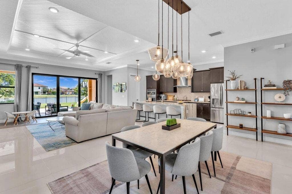12143 S Baypoint Circle, Parkland, FL 33076 Open-concept interior featuring large format tile flooring and a tray ceiling with recessed lighting