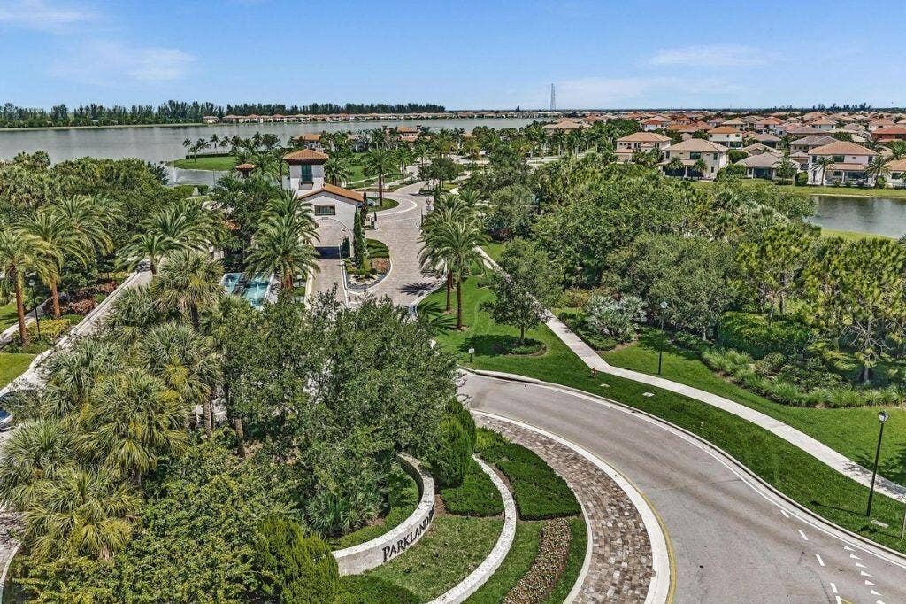 12143 S Baypoint Circle, Parkland, FL 33076 Aerial perspective highlighting a residential community entrance with a Mediterranean-style gatehouse