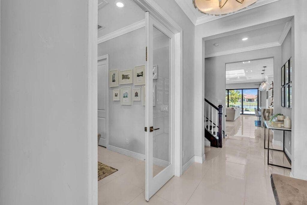 12143 S Baypoint Circle, Parkland, FL 33076 Foyer featuring polished tile flooring, recessed lighting, a staircase with dark wood-finish handrails and white balusters, and an arched entry to the main living area