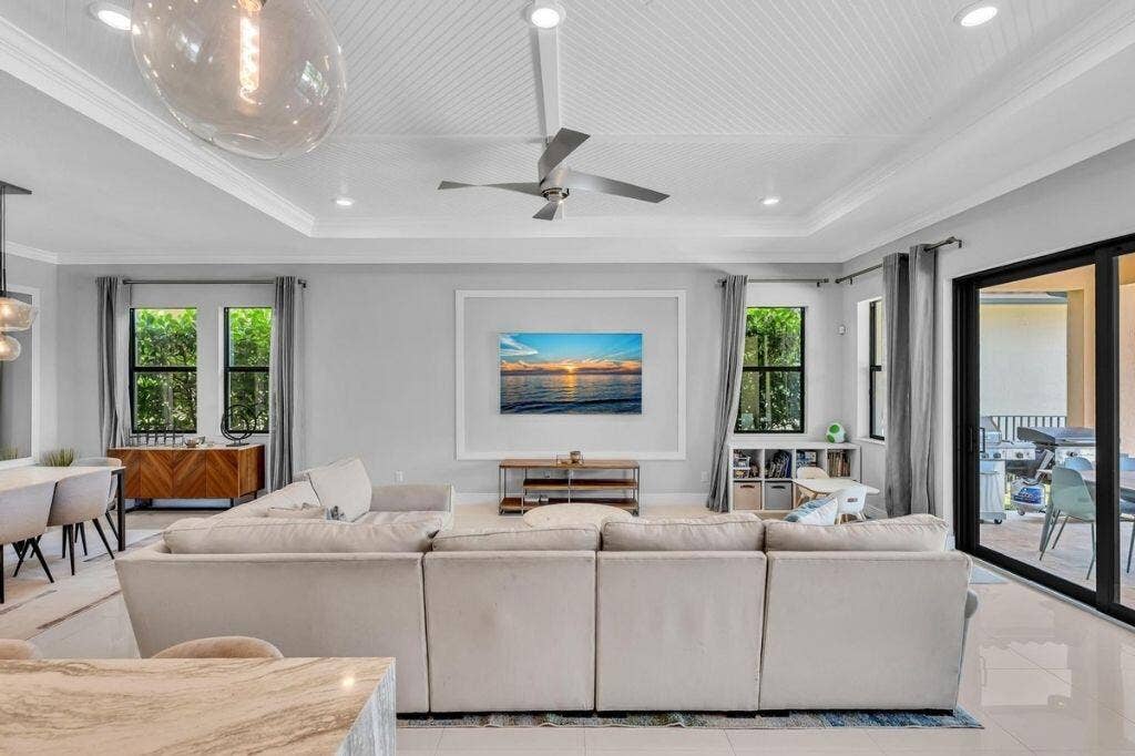 12143 S Baypoint Circle, Parkland, FL 33076 Spacious open-concept living area featuring a tray ceiling with beadboard detail, recessed lighting, and a ceiling fan