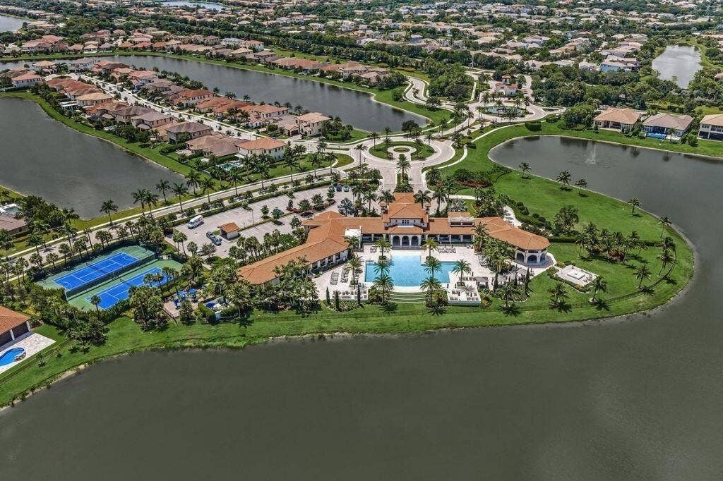 12143 S Baypoint Circle, Parkland, FL 33076 Clubhouse with a central swimming pool, multiple tennis courts, and surrounding residential properties