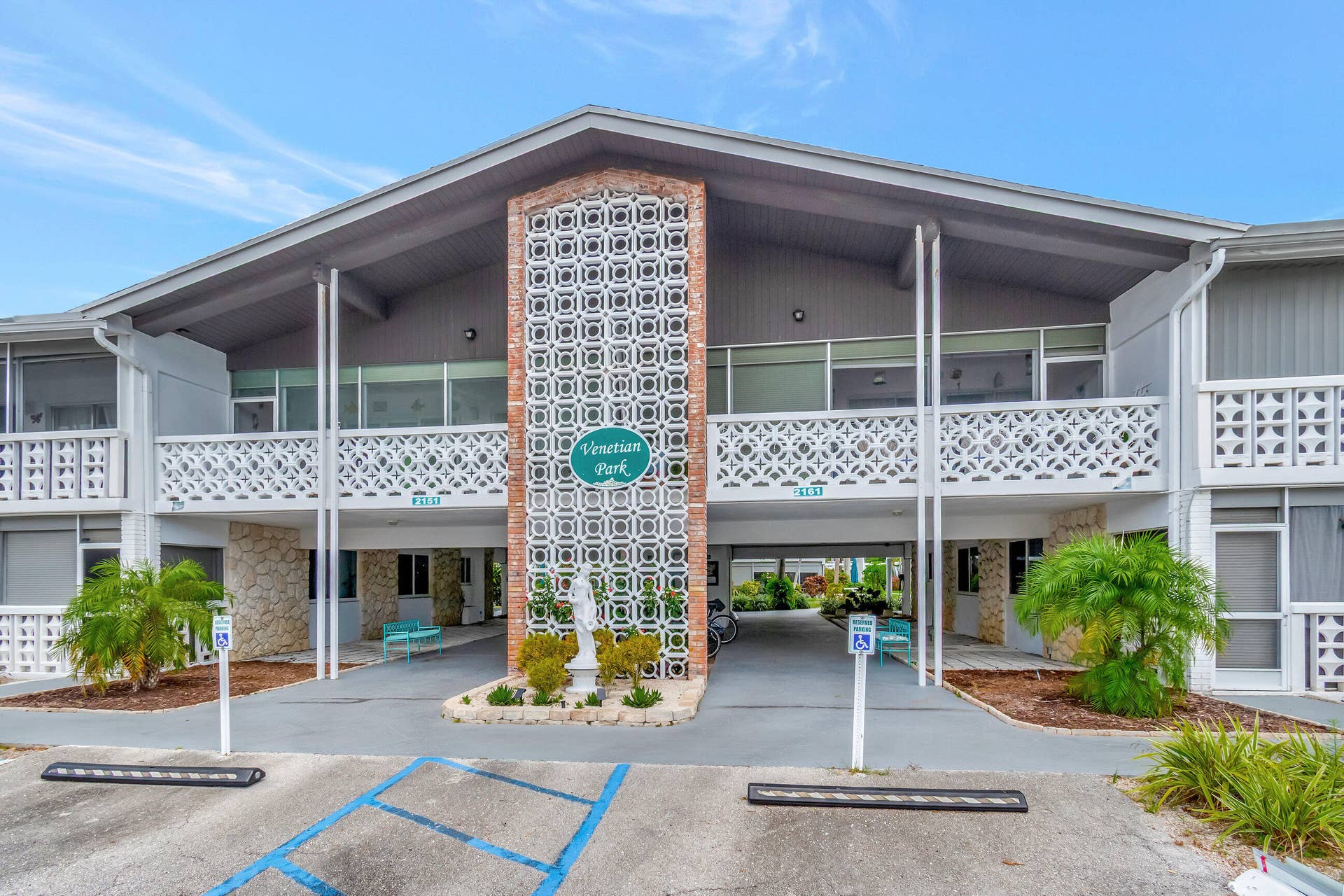 2161 NE 42nd Court, #116, Lighthouse Point, FL 33064 Two-story building featuring a prominent breezeway, decorative architectural block screens, textured stone accents, and an exterior of painted siding