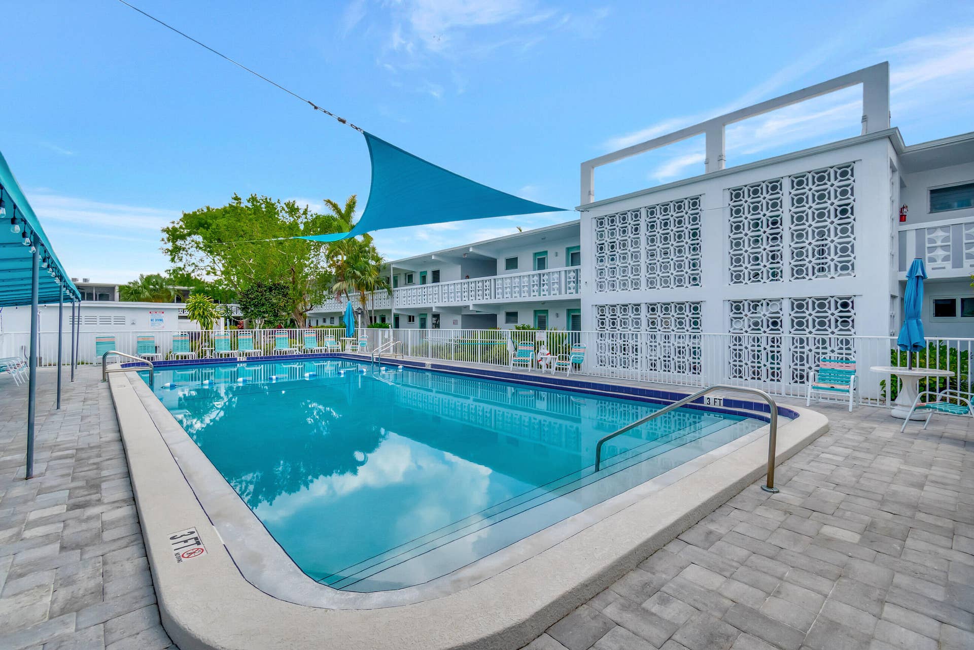 2161 NE 42nd Court, #116, Lighthouse Point, FL 33064 Outdoor swimming pool with integrated steps, surrounded by a paver patio and security fencing