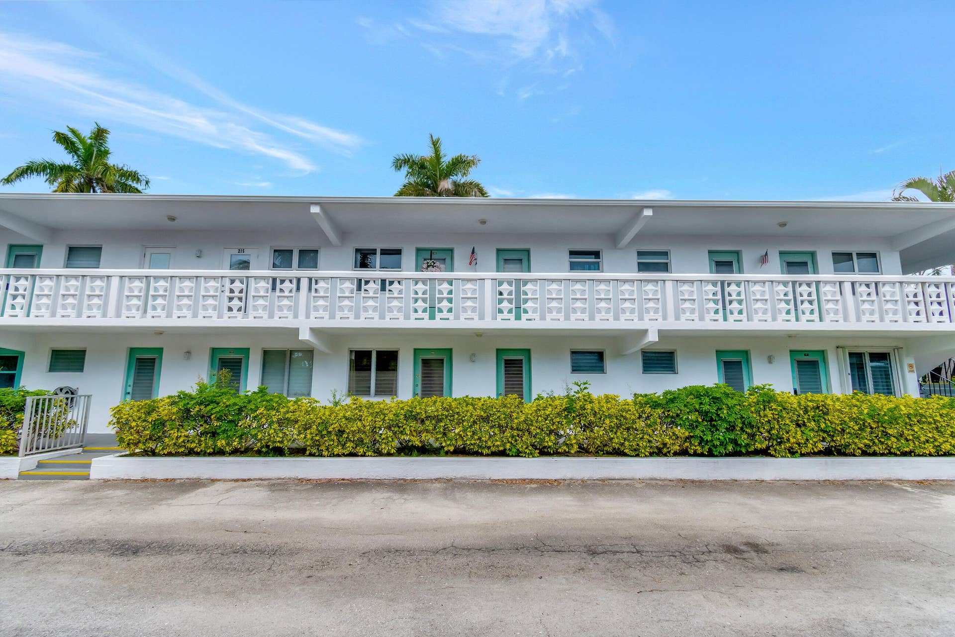 2161 NE 42nd Court, #116, Lighthouse Point, FL 33064 Two-story multi-unit building featuring white stucco exterior and decorative balcony railings