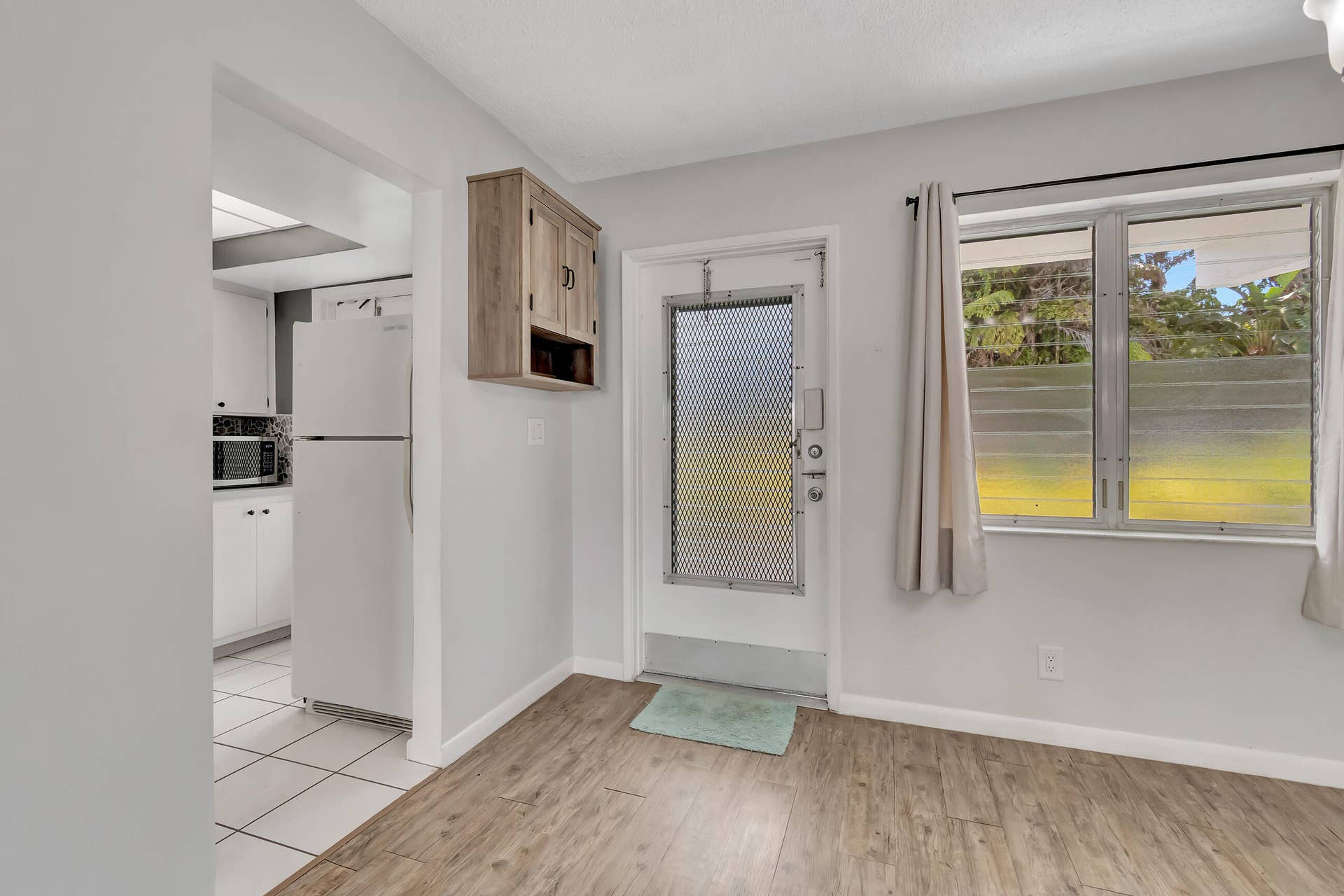 2161 NE 42nd Court, #116, Lighthouse Point, FL 33064 Kitchen with white cabinetry, white appliances, and a mosaic tile backsplash