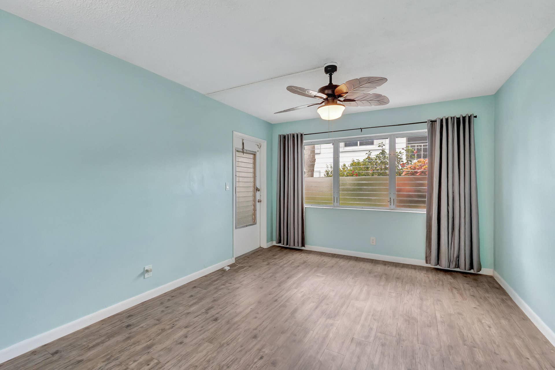 2161 NE 42nd Court, #116, Lighthouse Point, FL 33064 Wood-finish flooring, full-height windows, and a decorative ceiling fan with integrated lighting