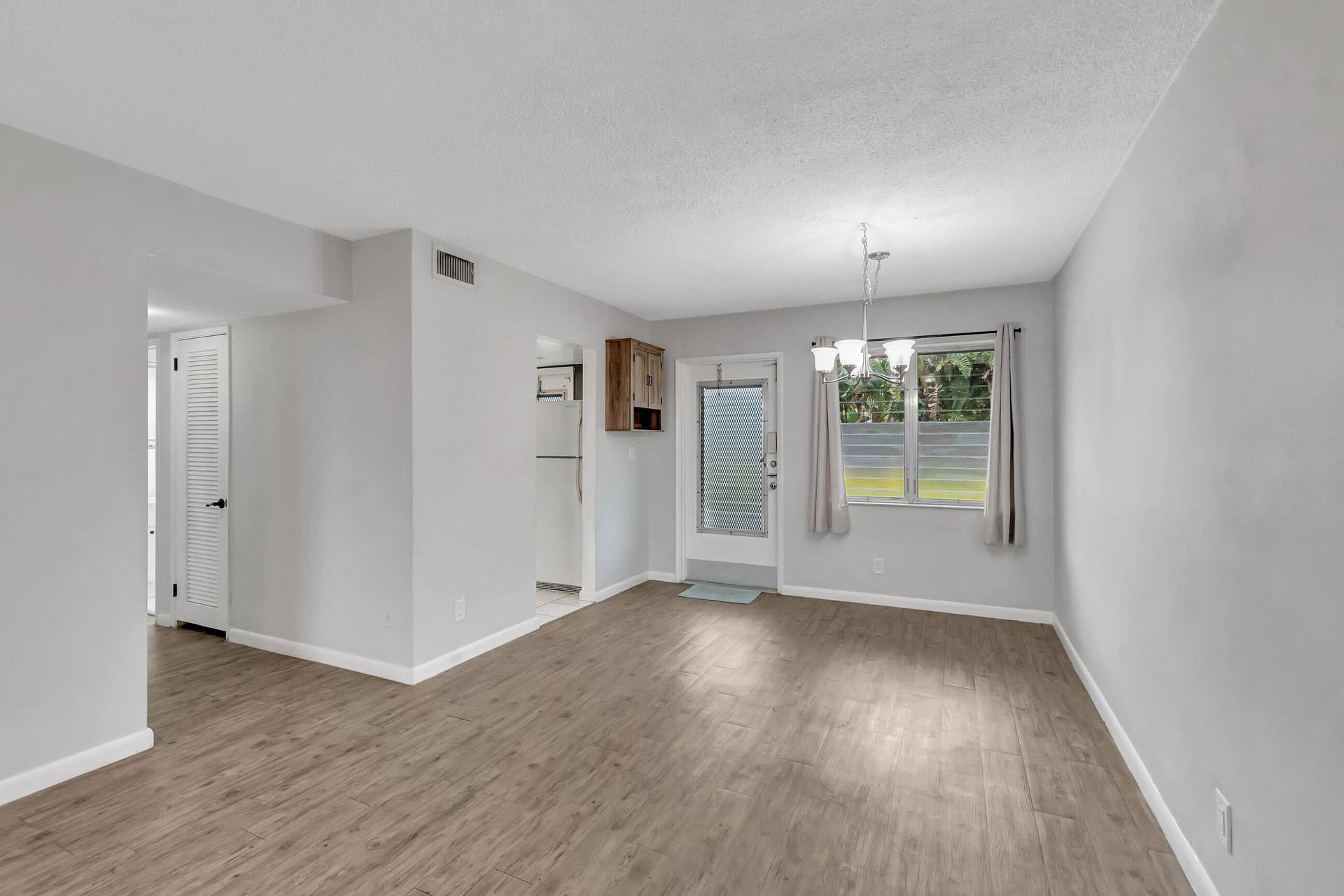 2161 NE 42nd Court, #116, Lighthouse Point, FL 33064 Light-toned walls, wood-finish flooring, and a dining fixture