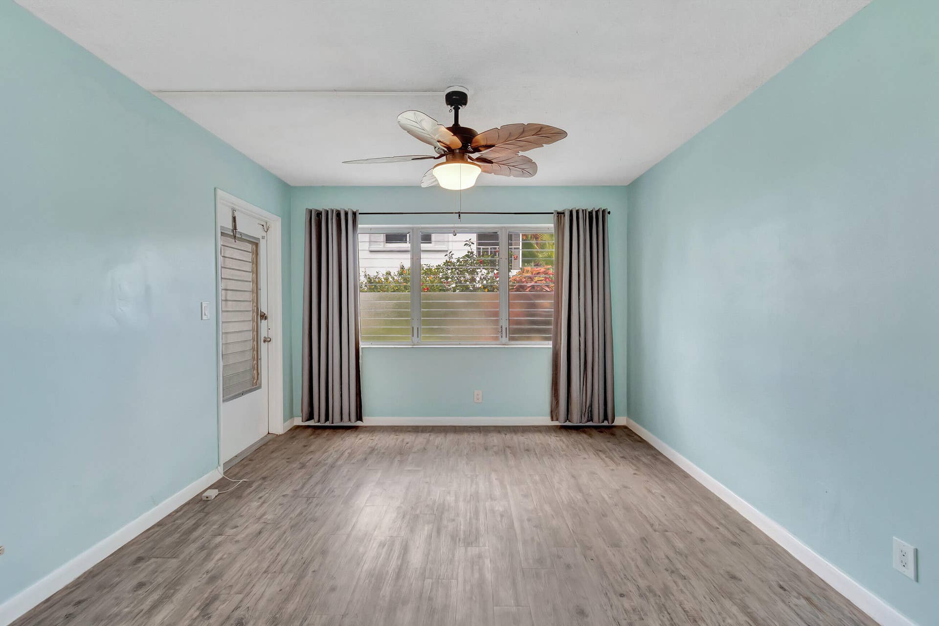 2161 NE 42nd Court, #116, Lighthouse Point, FL 33064 Wood-finish flooring, light blue walls, and a ceiling fan with integrated lighting