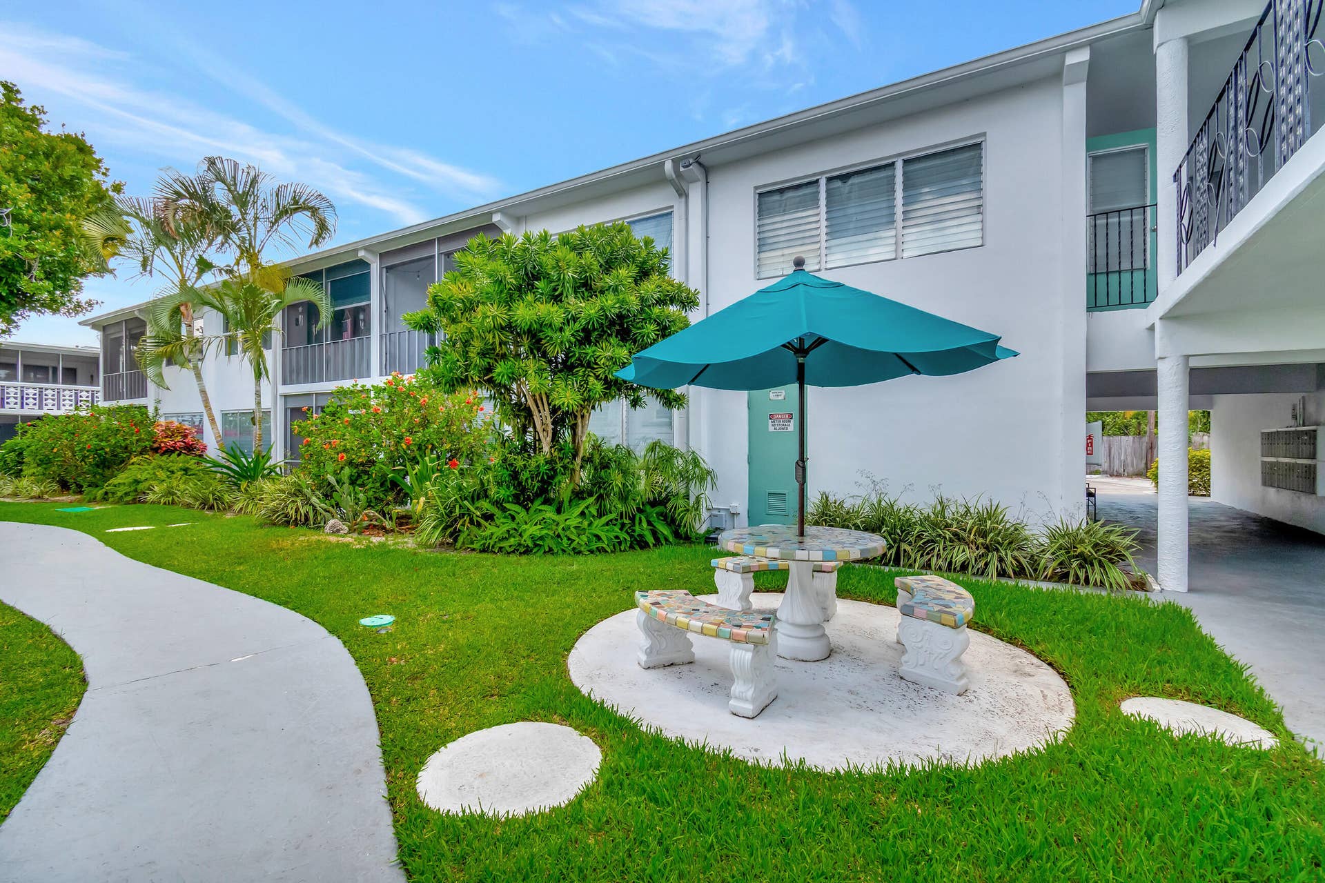 2161 NE 42nd Court, #116, Lighthouse Point, FL 33064 Manicured landscaping, concrete pathways, and a built-in outdoor seating area