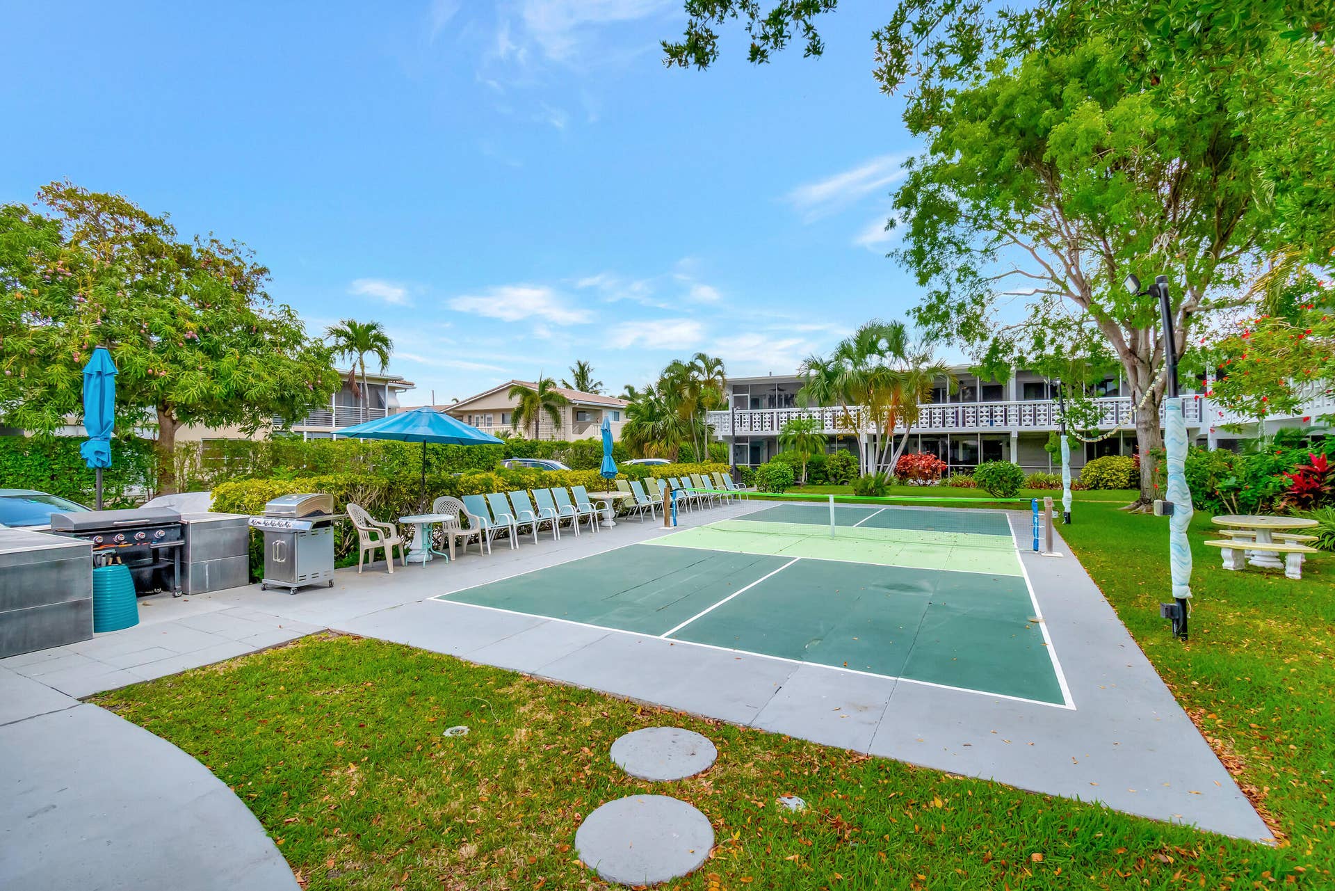 2161 NE 42nd Court, #116, Lighthouse Point, FL 33064 Pickleball court, paved patio, outdoor seating, barbecue grills, and manicured landscaping