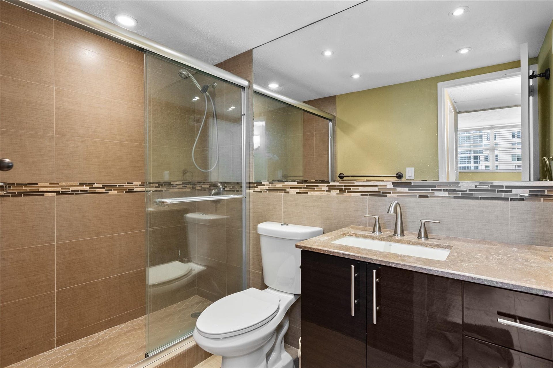 4250 GALT OCEAN Drive, #8L, Fort Lauderdale, Fort Lauderdale, FL 33308 Glass-enclosed shower with a tiled surround, integrated tile accent band, and recessed lighting