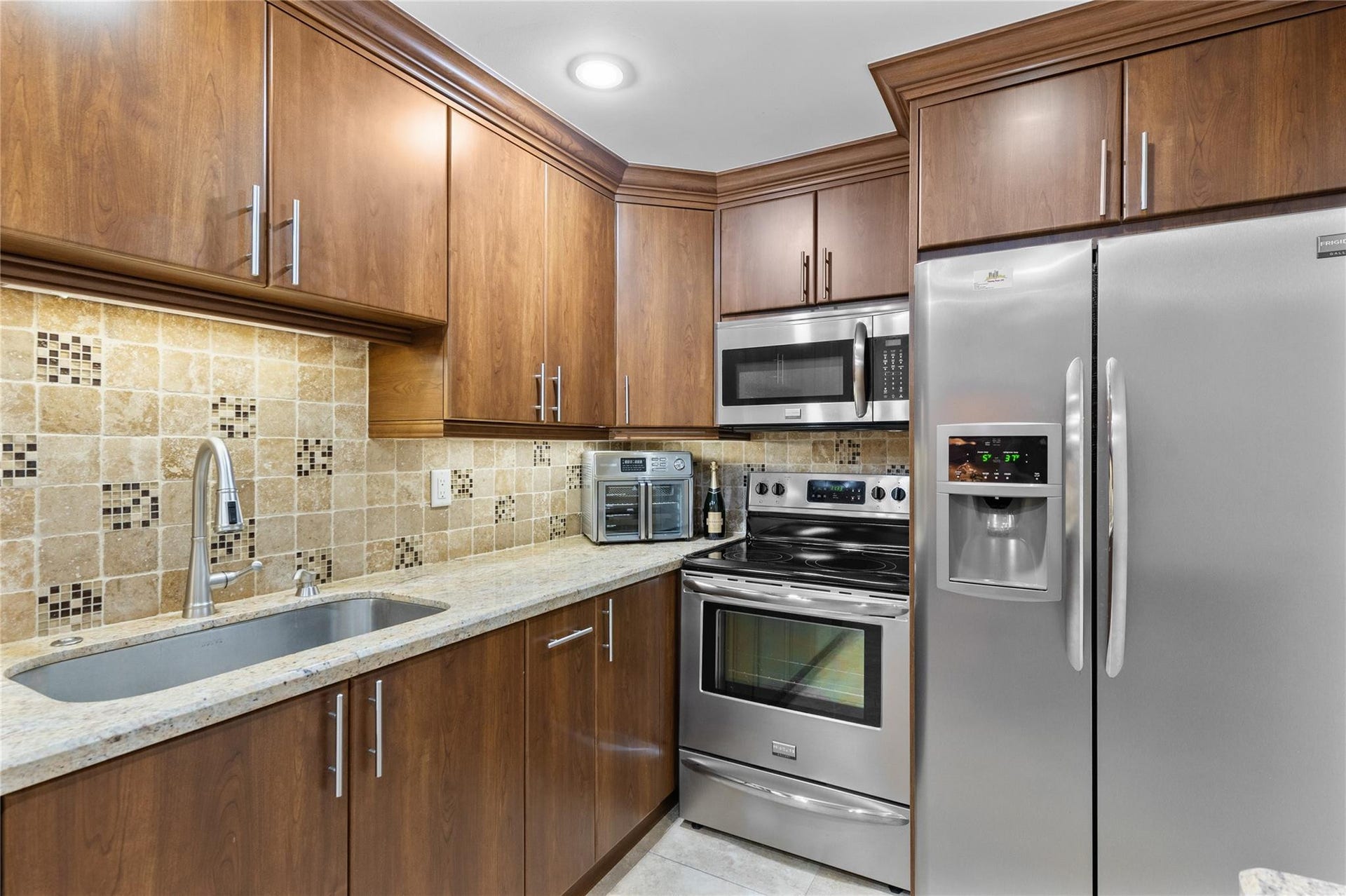 4250 GALT OCEAN Drive, #8L, Fort Lauderdale, Fort Lauderdale, FL 33308 Full-height wood-finish cabinetry, stainless steel appliances, granite countertops, tile backsplash, and a contemporary gooseneck faucet
