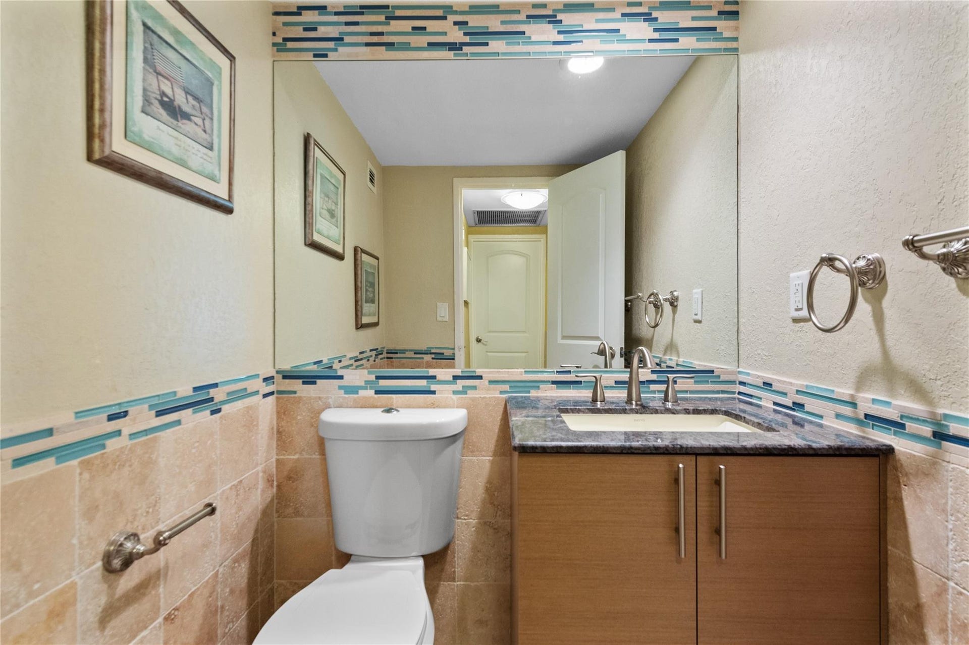 4250 GALT OCEAN Drive, #8L, Fort Lauderdale, Fort Lauderdale, FL 33308 Full-height vanity mirror, stone-finish countertop, undermount sink, wood-finish cabinetry, and decorative tile accent