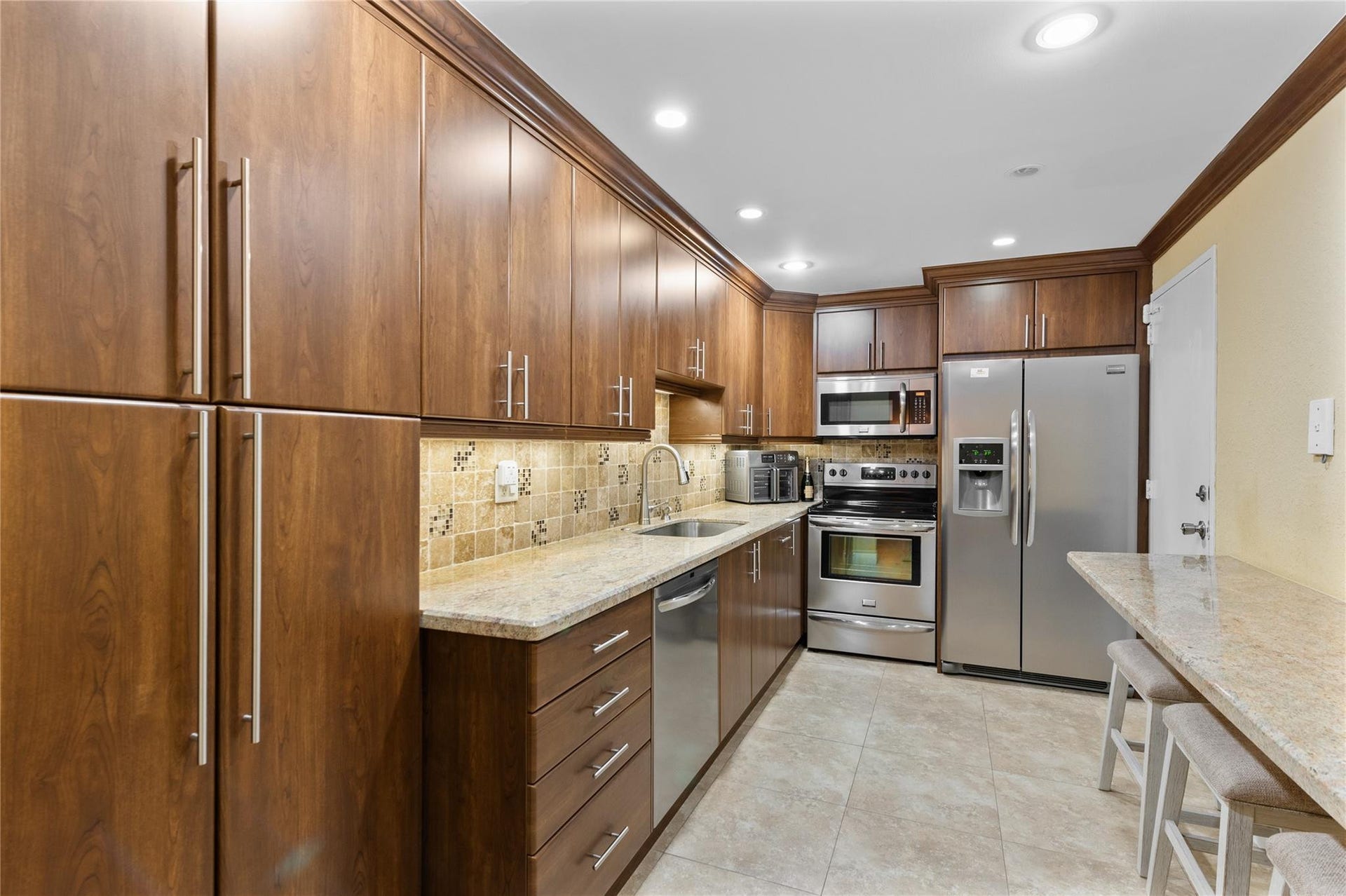 4250 GALT OCEAN Drive, #8L, Fort Lauderdale, Fort Lauderdale, FL 33308 Kitchen featuring wood-finish cabinetry, stainless steel appliances, granite countertops, and a tiled backsplash