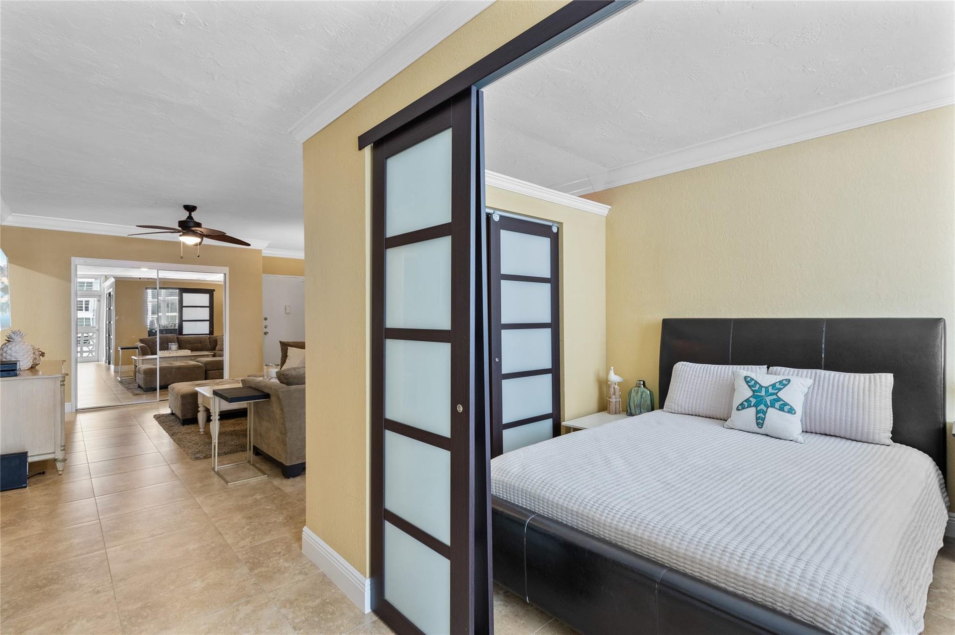 4250 GALT OCEAN Drive, #8L, Fort Lauderdale, Fort Lauderdale, FL 33308 Sliding panel doors with frosted inserts, tile flooring, crown molding, and a ceiling fan with light fixture