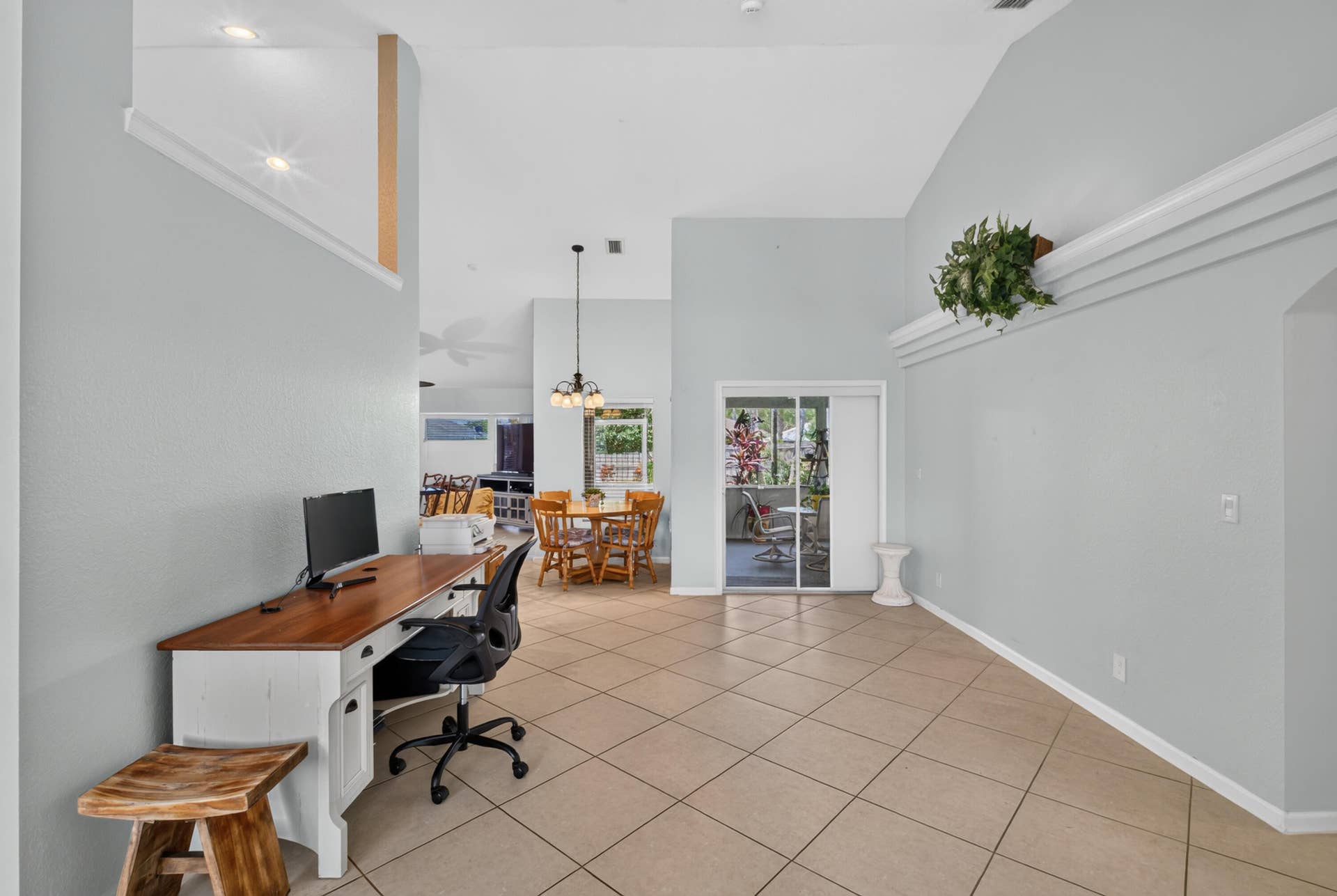 3274 SW CRUMPACKER Street, Port St Lucie, FL 34953 Vaulted ceilings with architectural ledge, tile flooring, and sliding glass door access