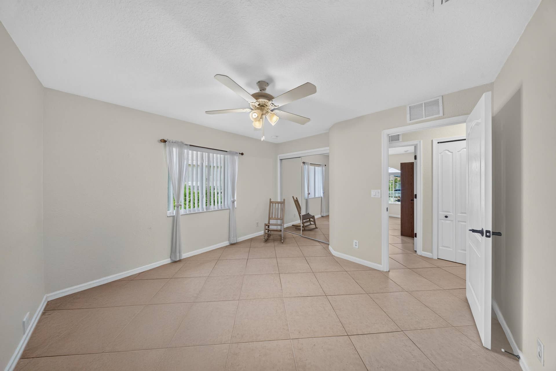 3274 SW CRUMPACKER Street, Port St Lucie, FL 34953 Spacious room featuring tile flooring, a ceiling fan with integrated lighting, and a window with vertical blinds