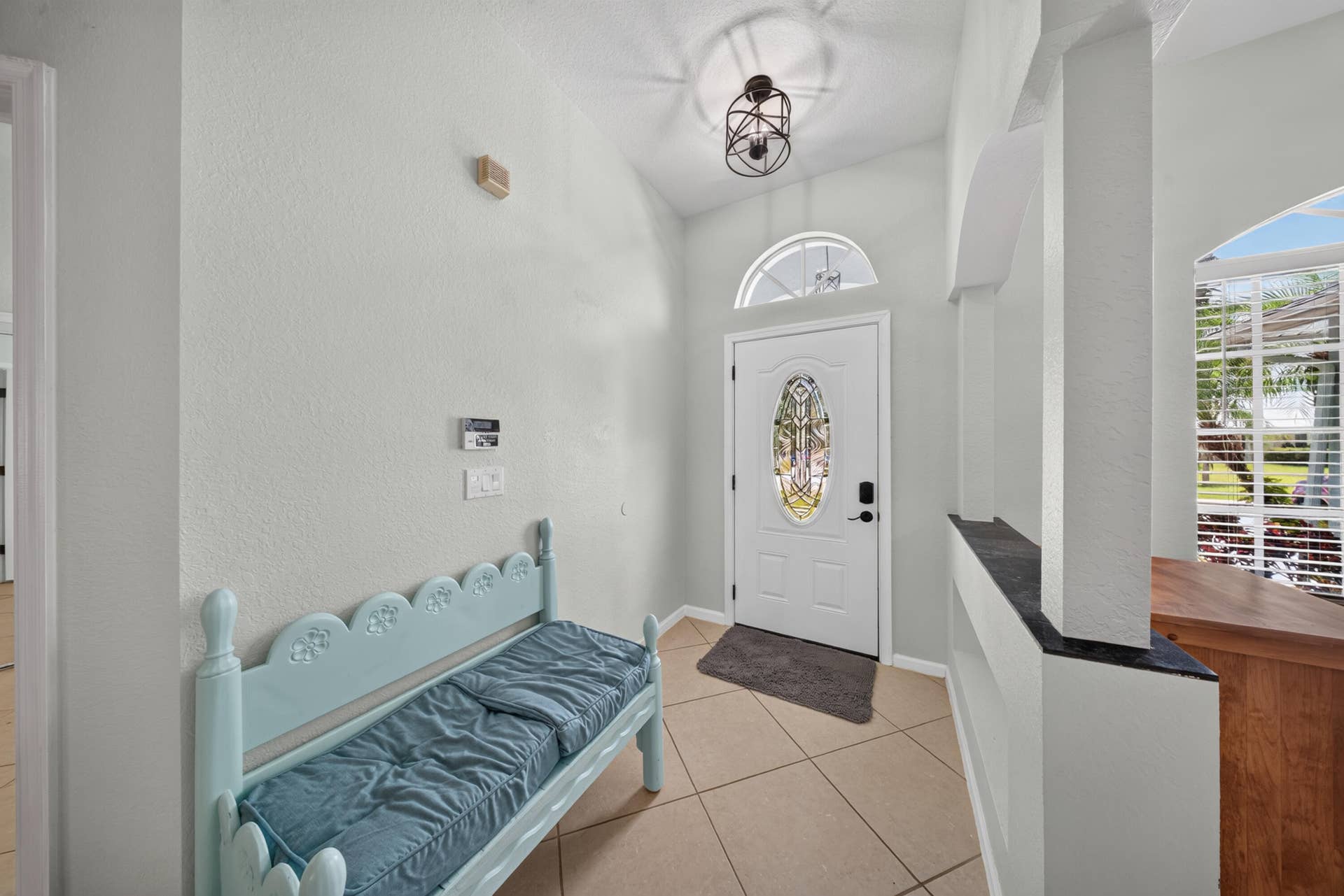 3274 SW CRUMPACKER Street, Port St Lucie, FL 34953 Entryway featuring tile flooring, a decorative front door with an arched transom, a semi-flush mount light fixture, and arched interior openings