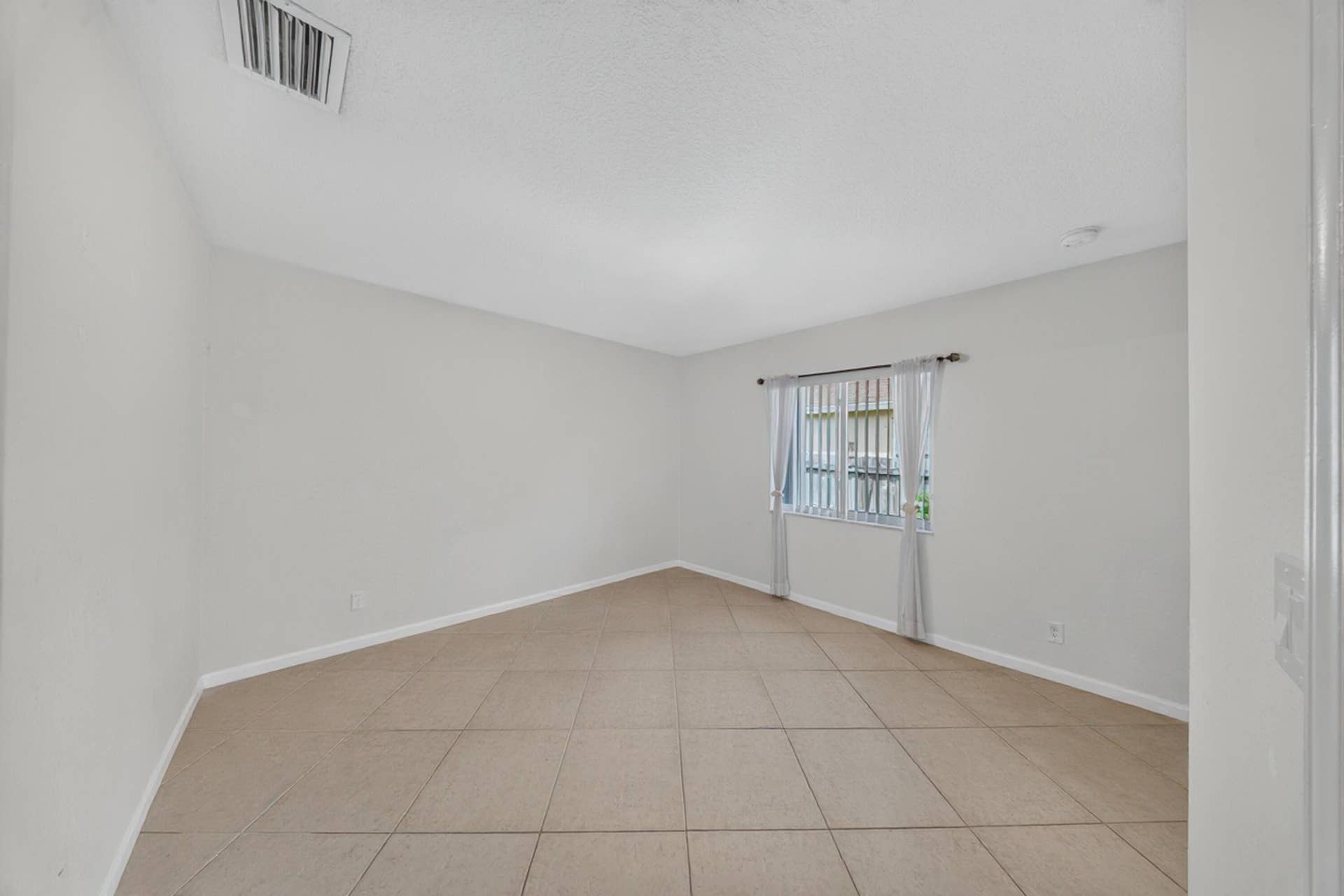 3274 SW CRUMPACKER Street, Port St Lucie, FL 34953 Neutral wall color, tiled flooring, window with security bars, ceiling-mounted ventilation