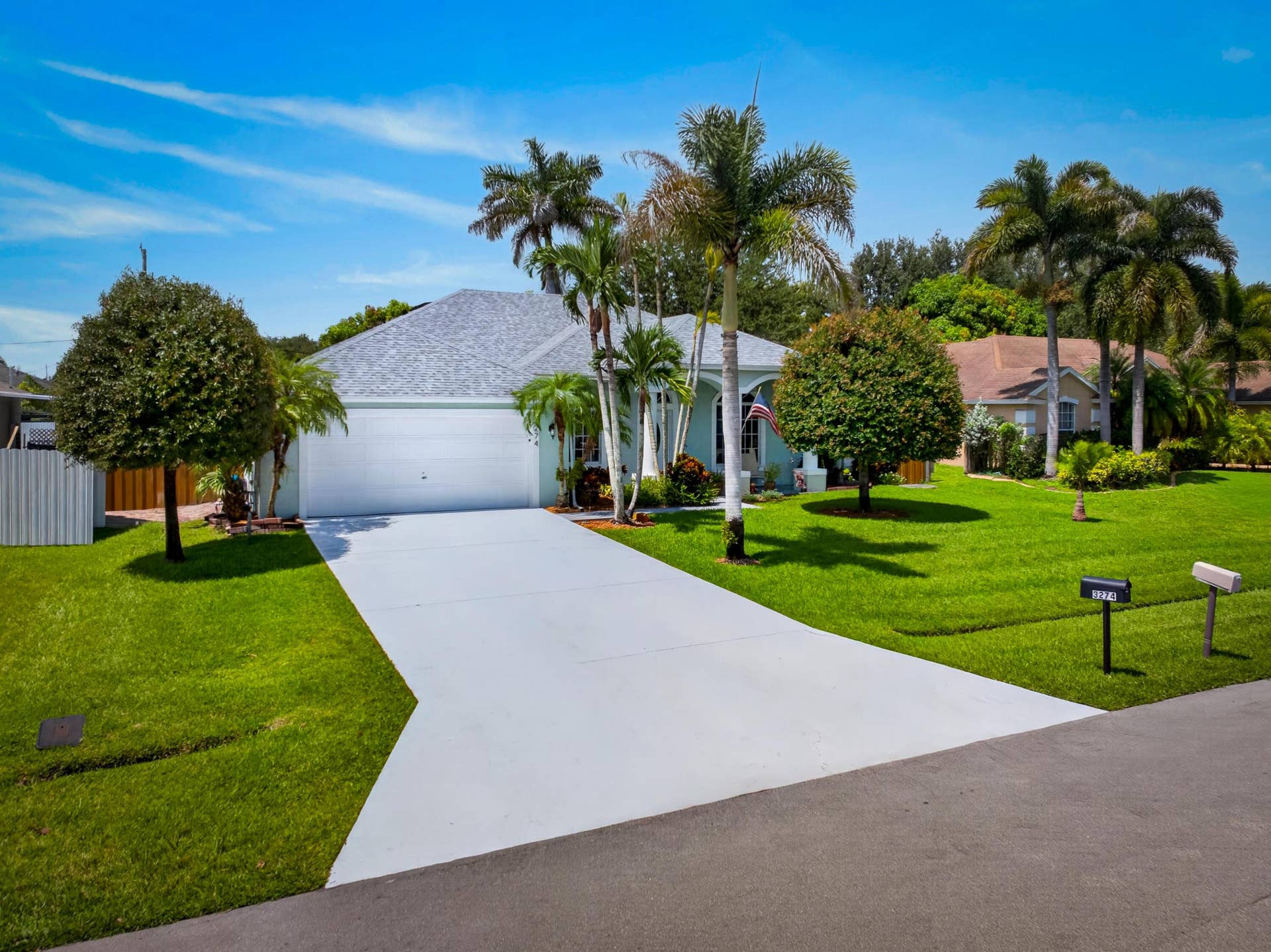 3274 SW CRUMPACKER Street, Port St Lucie, FL 34953 Single-story residence featuring a two-car garage, concrete driveway, and a shingle roof