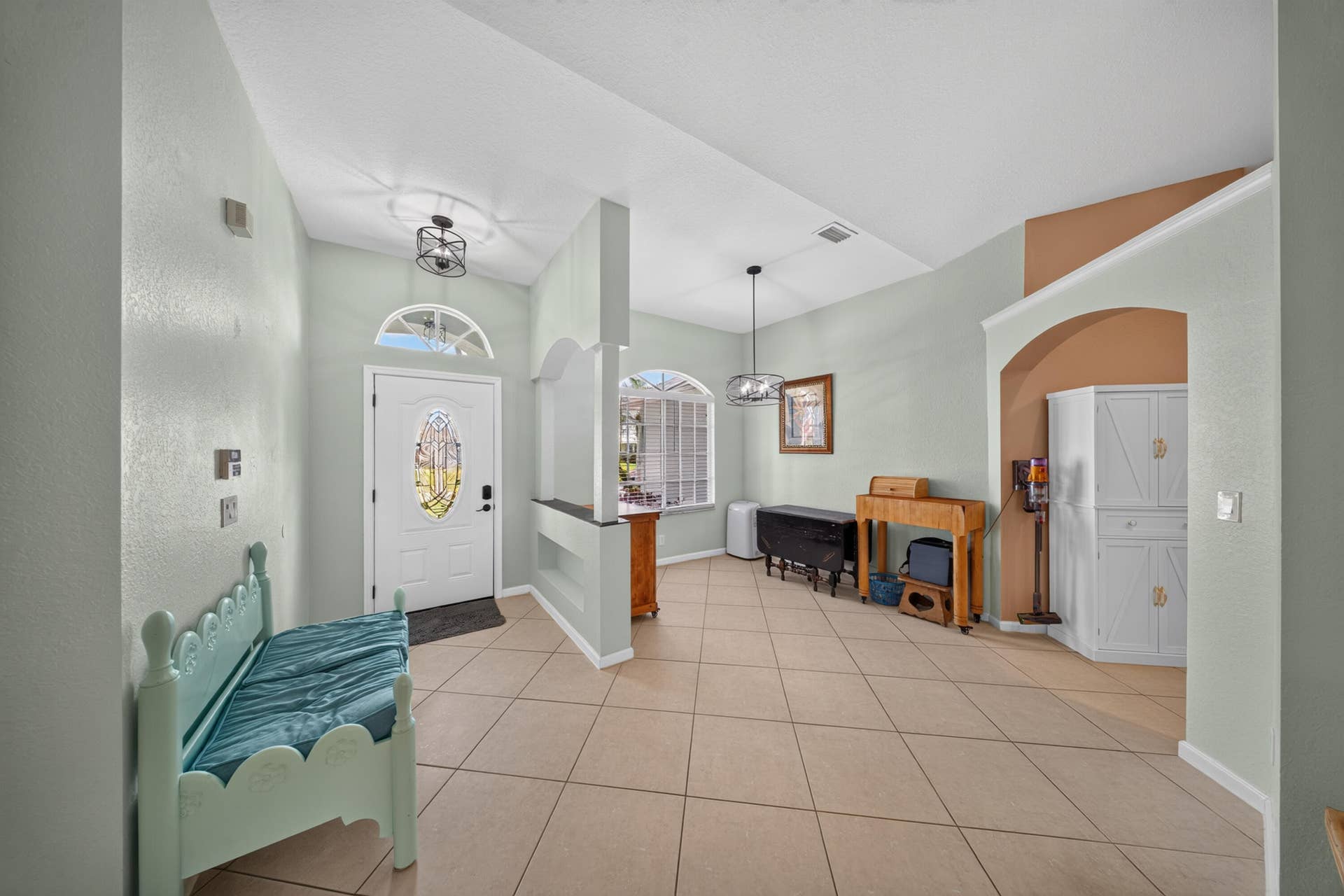 3274 SW CRUMPACKER Street, Port St Lucie, FL 34953 Entryway featuring a white door with decorative glass, arched transom window, and a ceiling-mounted light fixture