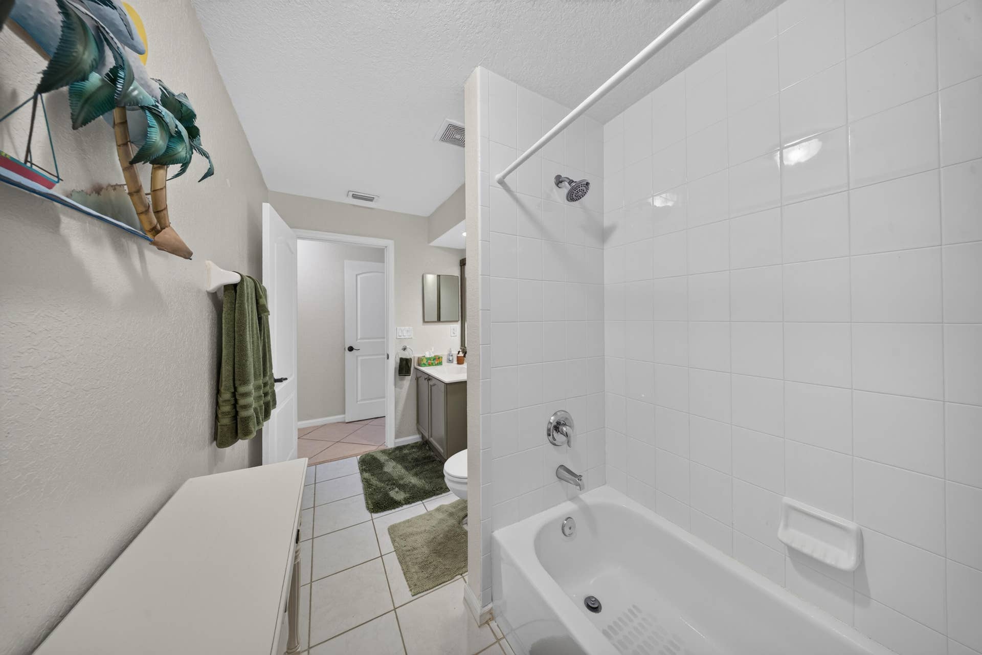 3274 SW CRUMPACKER Street, Port St Lucie, FL 34953 Bathroom featuring a white tiled shower with a bathtub, chrome fixtures, and tile flooring