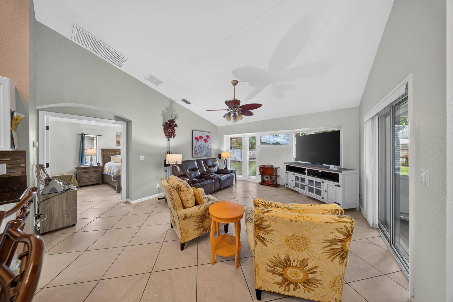 3274 SW CRUMPACKER Street, Port St Lucie, FL 34953 Vaulted ceilings, tile flooring, sliding glass doors, and an arched doorway