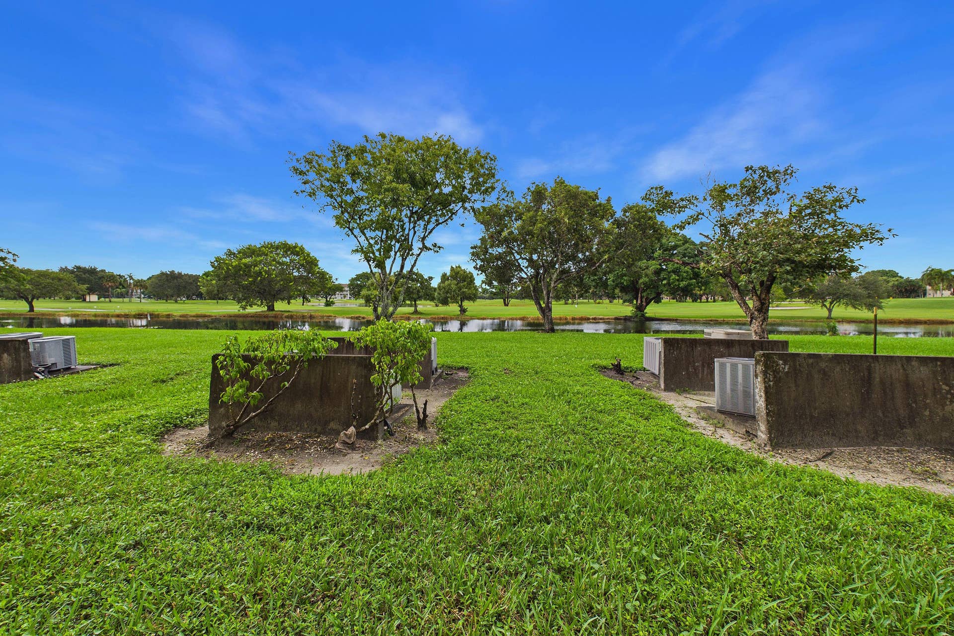 13155 SW 7TH Court, #103E, Pembroke Pines, FL 33027 Expansive green space featuring mature trees and a tranquil water feature