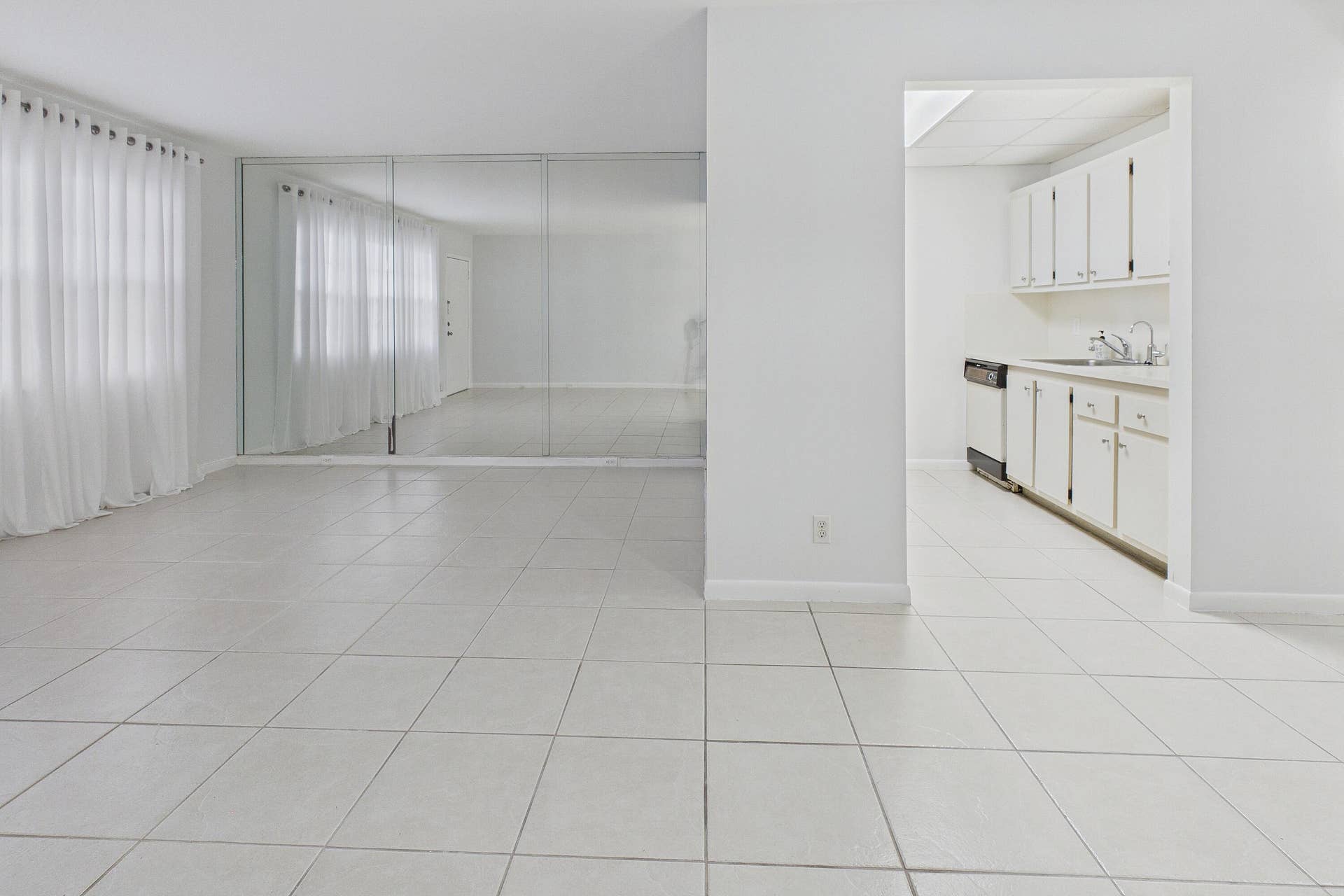 13155 SW 7TH Court, #103E, Pembroke Pines, FL 33027 Expansive tiled flooring throughout, mirrored wall, and sheer window treatments