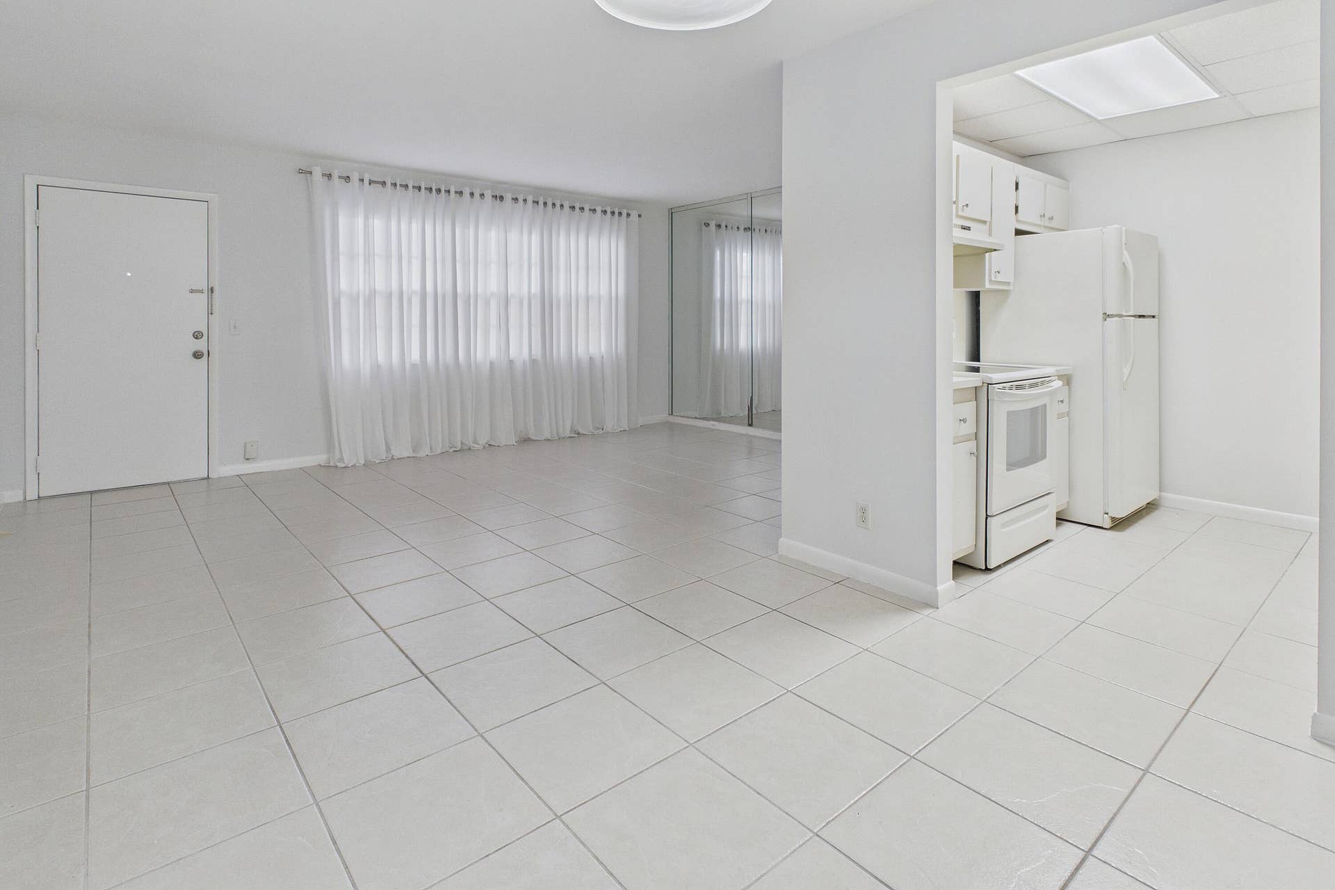 13155 SW 7TH Court, #103E, Pembroke Pines, FL 33027 Tile flooring throughout, white kitchen cabinetry, white appliances, and a rectangular ceiling light fixture